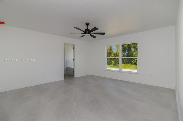 empty room featuring a ceiling fan, baseboards, and a textured ceiling