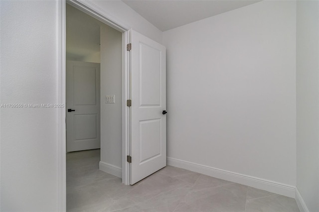 spare room with light tile patterned floors and baseboards