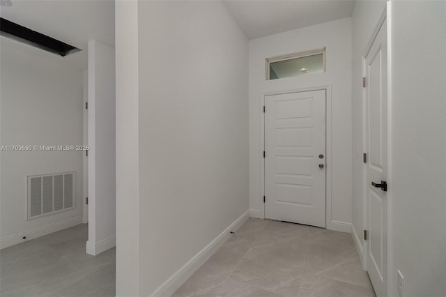 hall featuring visible vents and baseboards