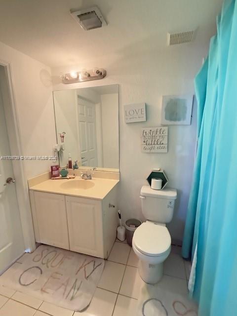 bathroom featuring tile patterned flooring, vanity, and toilet