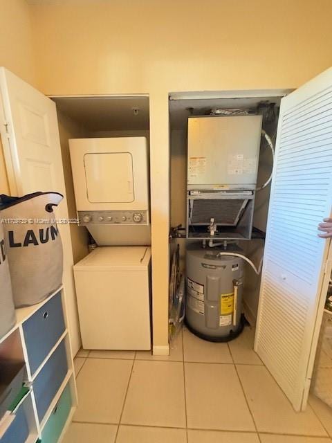1967 Marsh Harbor Dr Unit 313, Riviera Beach, FL 33404 - laundry area with stacked washer / dryer, water heater, and tile patterned floors