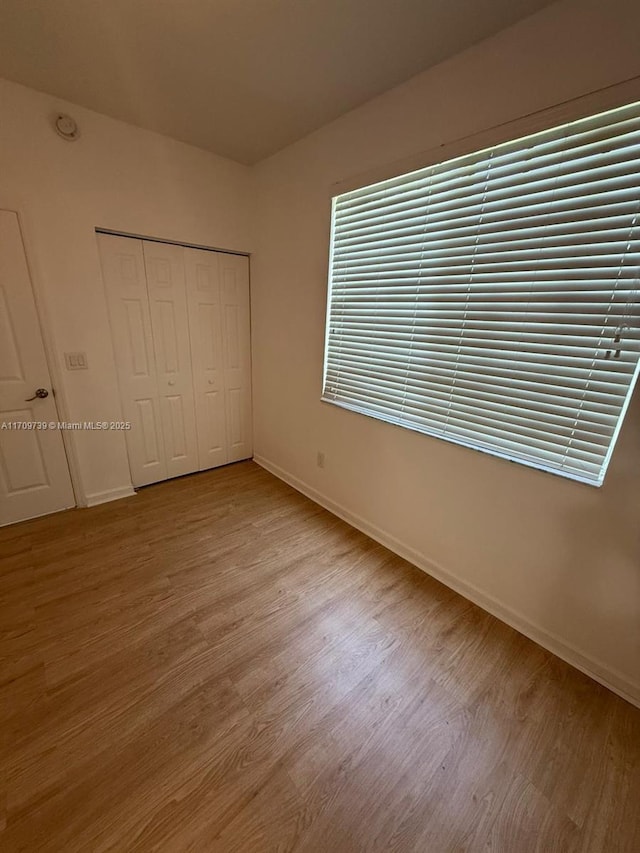 1967 Marsh Harbor Dr Unit 313, Riviera Beach, FL 33404 - unfurnished bedroom featuring wood finished floors and a closet