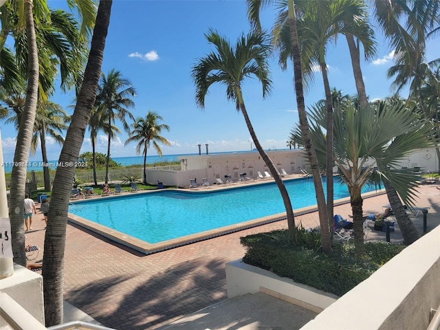 view of swimming pool with a water view and a patio