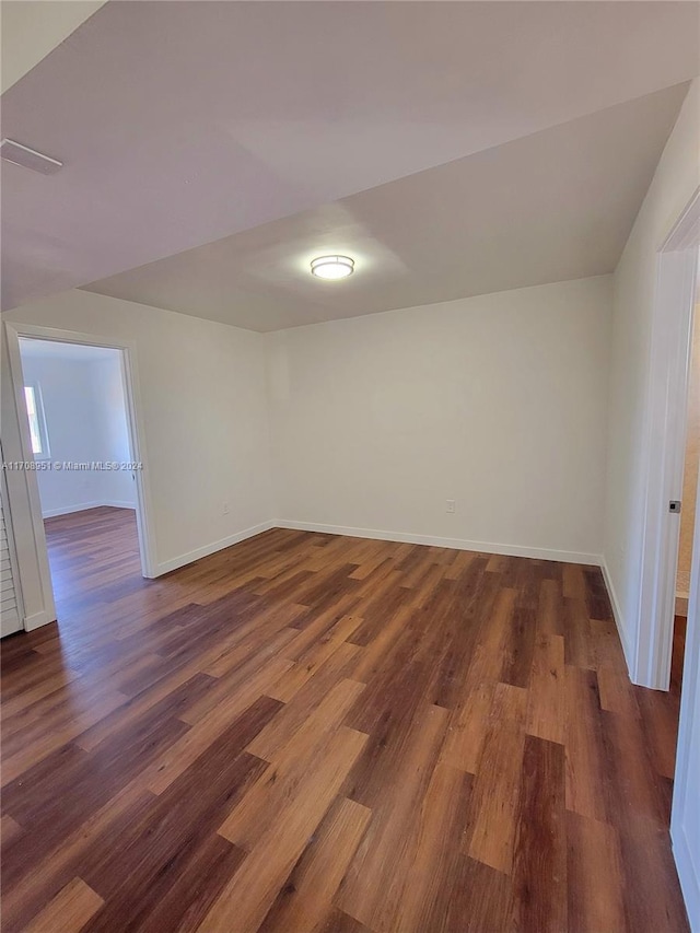 unfurnished room with dark hardwood / wood-style flooring