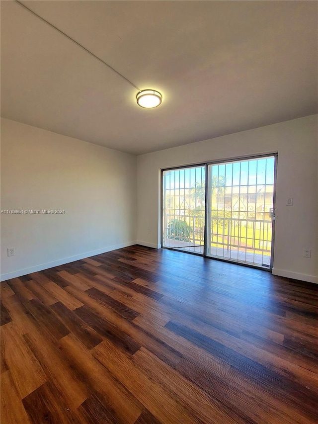 unfurnished room with a wealth of natural light and dark wood-type flooring