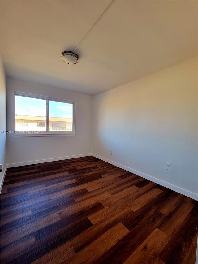 spare room with dark hardwood / wood-style flooring