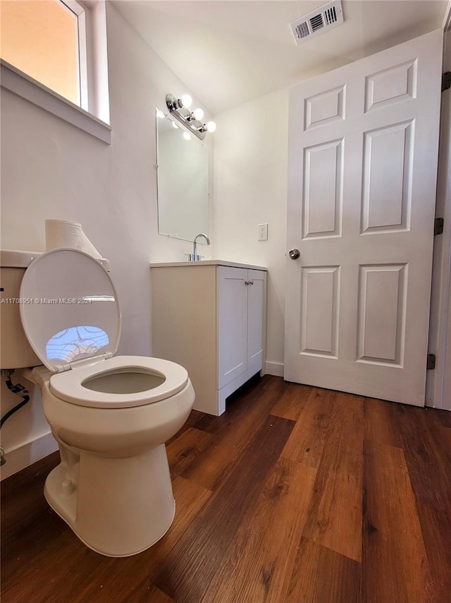 bathroom with wood-type flooring, vanity, and toilet