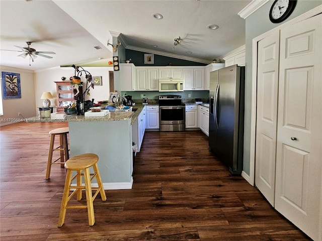 kitchen with white cabinets, a kitchen breakfast bar, kitchen peninsula, and stainless steel appliances