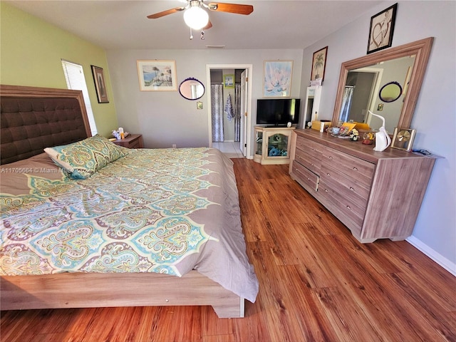 bedroom featuring hardwood / wood-style floors, ceiling fan, and connected bathroom