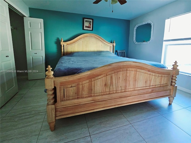 tiled bedroom featuring ceiling fan