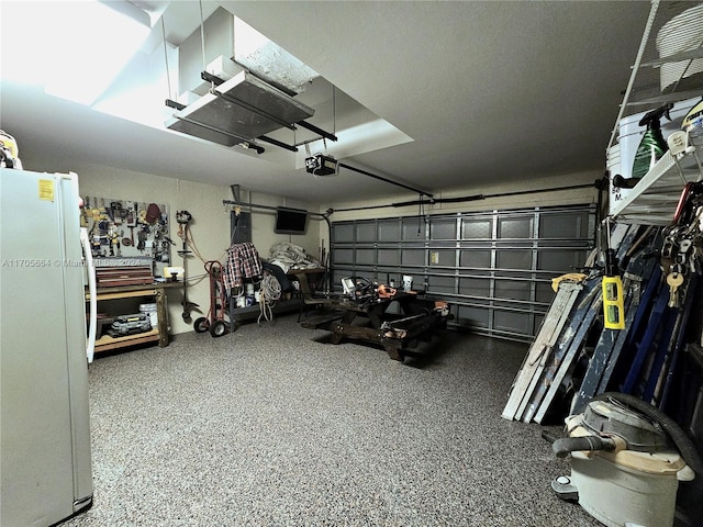 garage with white refrigerator and a garage door opener