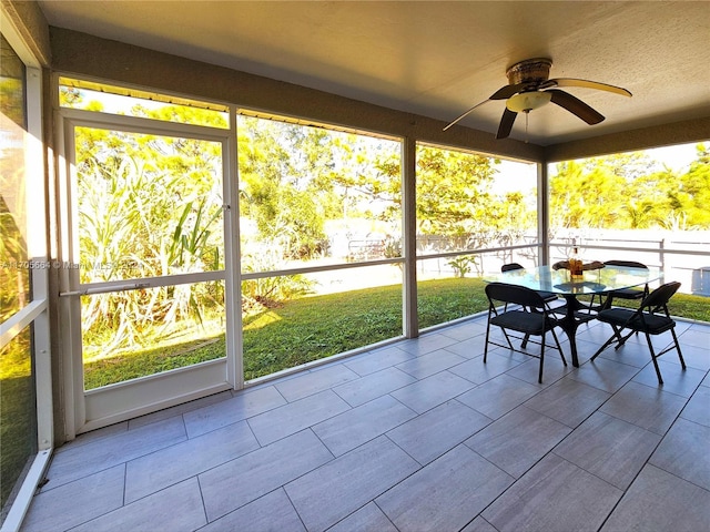 unfurnished sunroom with ceiling fan