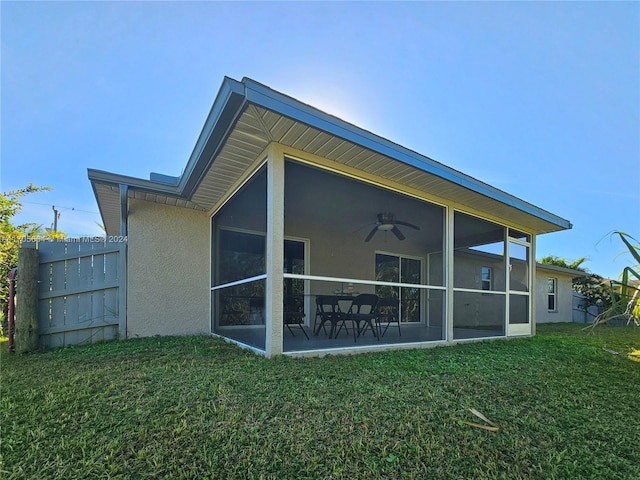 back of house with ceiling fan, a lawn, and a sunroom