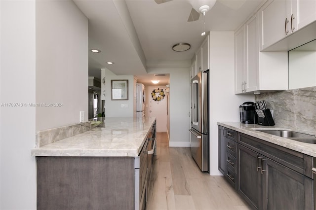 kitchen with white cabinets, dark brown cabinets, light hardwood / wood-style floors, and high end refrigerator