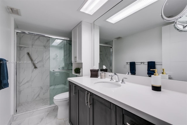 bathroom featuring vanity, toilet, and a shower with shower door