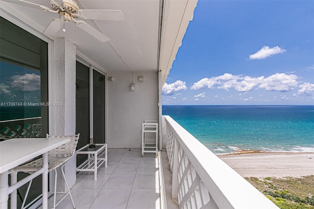 balcony featuring a view of the beach and a water view