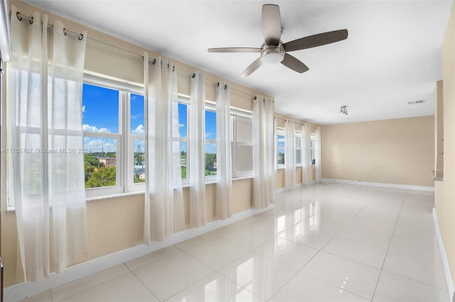 unfurnished sunroom with ceiling fan