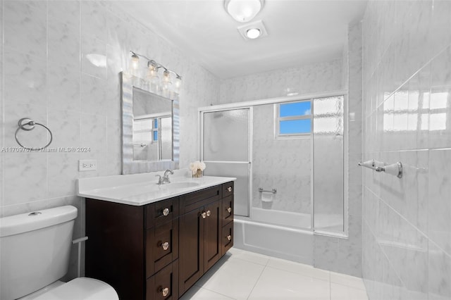 full bathroom with vanity, tile patterned flooring, toilet, enclosed tub / shower combo, and tile walls