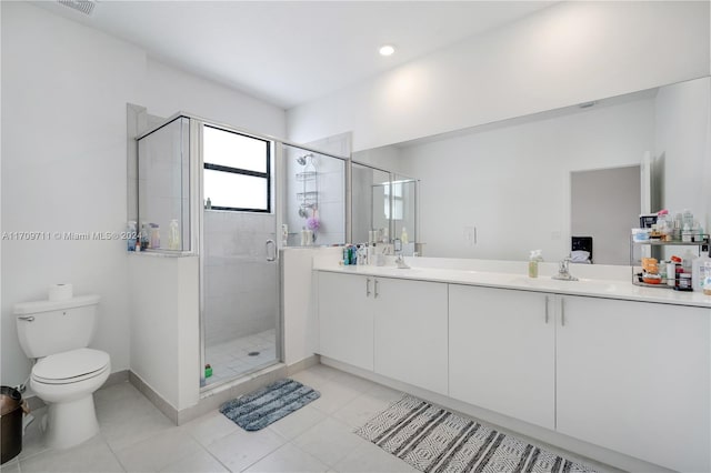 bathroom featuring tile patterned floors, vanity, toilet, and a shower with shower door