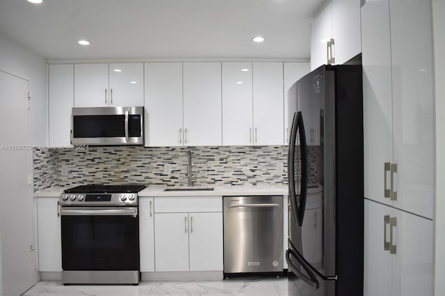 kitchen featuring white cabinets, backsplash, and stainless steel appliances