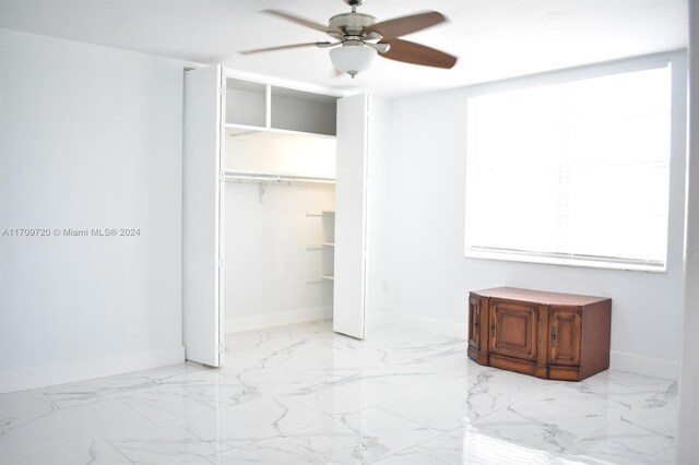 unfurnished bedroom with ceiling fan and a closet