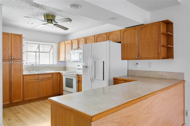 kitchen with sink, light hardwood / wood-style flooring, kitchen peninsula, a textured ceiling, and white appliances