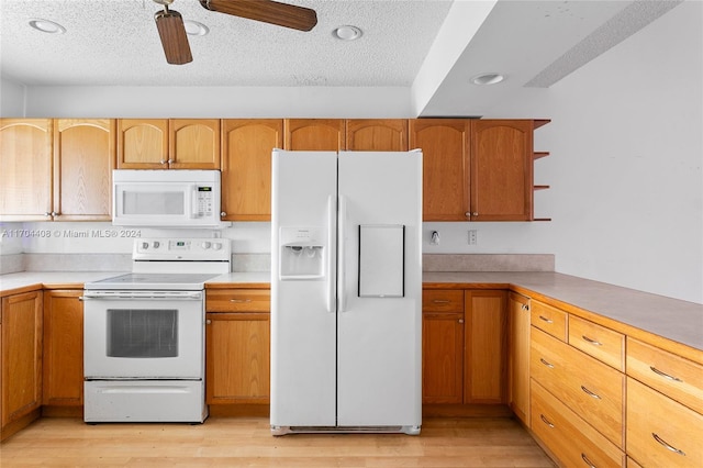 kitchen featuring ceiling fan, light wood-type flooring, white appliances, and a textured ceiling