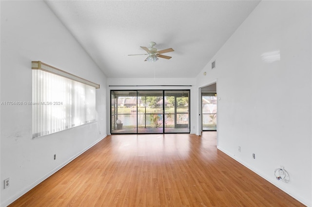 empty room featuring ceiling fan, light wood-type flooring, and high vaulted ceiling