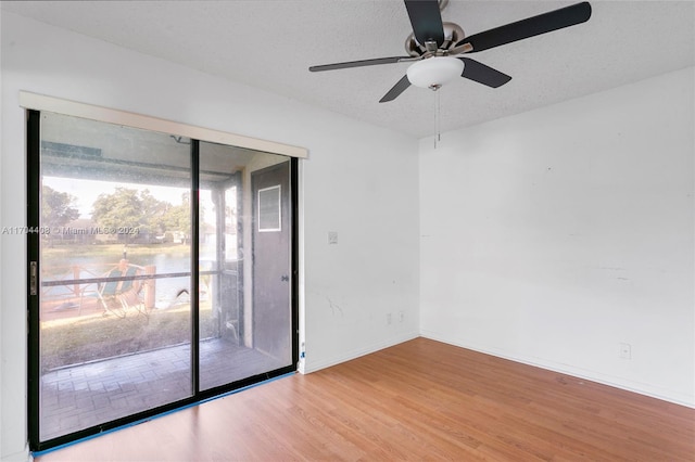 spare room with ceiling fan, light hardwood / wood-style floors, and a textured ceiling