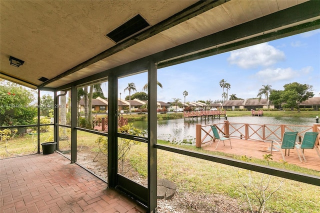 unfurnished sunroom with plenty of natural light and a water view