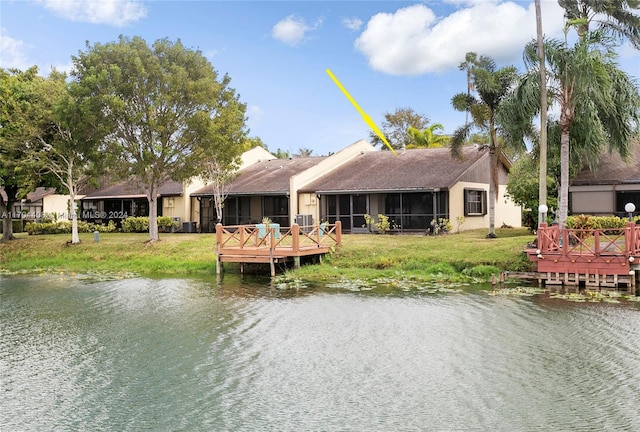 rear view of house featuring a sunroom and a water view