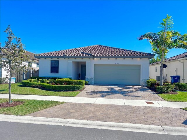 mediterranean / spanish-style home with a garage and central AC