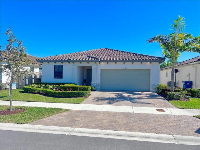 mediterranean / spanish-style house with cooling unit and a garage