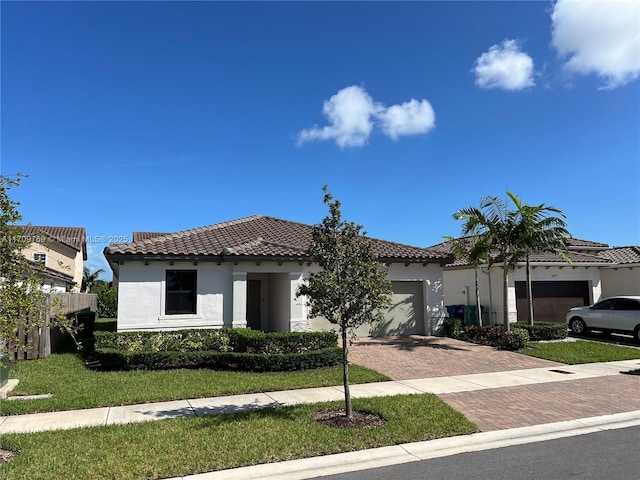 mediterranean / spanish-style house with a garage and a front lawn