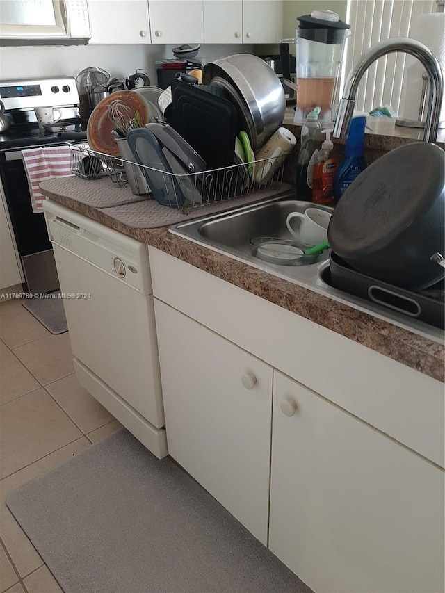 kitchen featuring dishwasher, white cabinets, light tile patterned flooring, and stainless steel range with electric stovetop