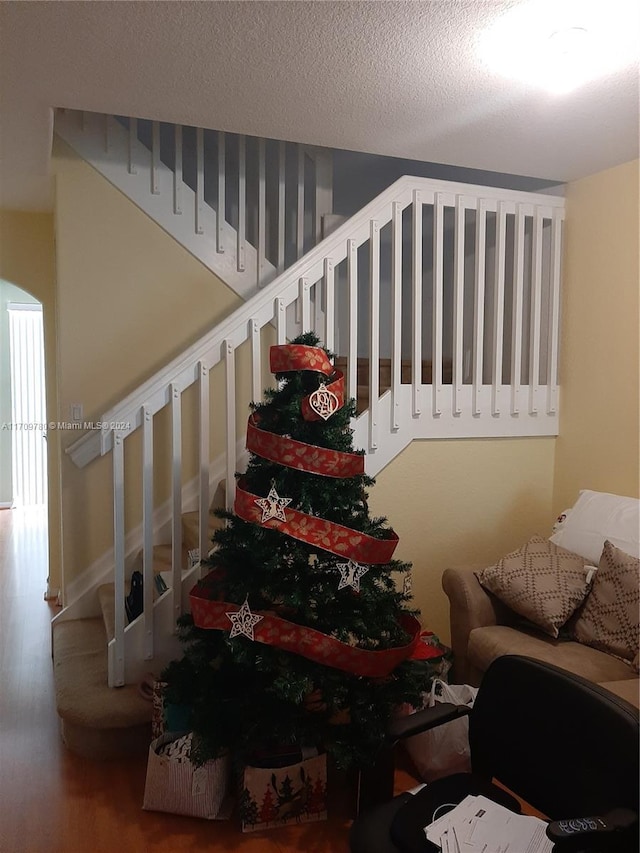 stairway featuring wood-type flooring and a textured ceiling