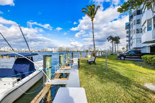 dock area with a lawn and a water view