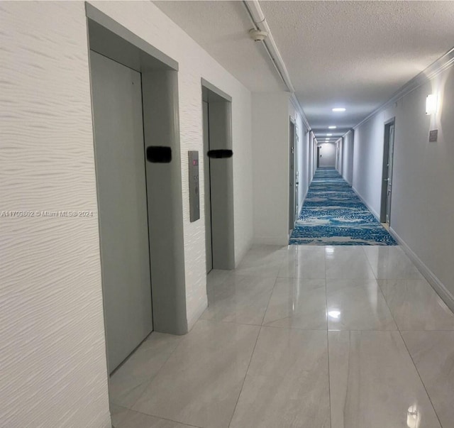 hallway featuring elevator, light tile patterned flooring, a textured ceiling, and ornamental molding