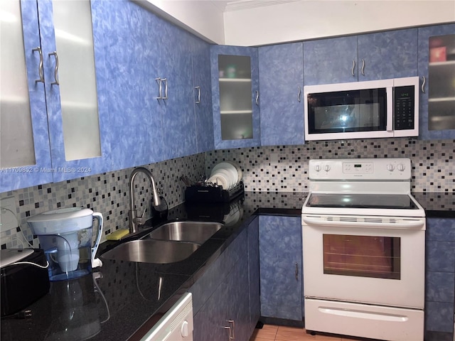 kitchen featuring sink, tasteful backsplash, dark stone counters, white appliances, and light tile patterned flooring