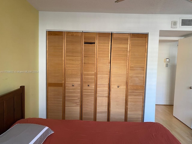 unfurnished bedroom with light hardwood / wood-style floors and a closet