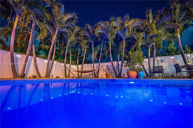 view of pool at twilight