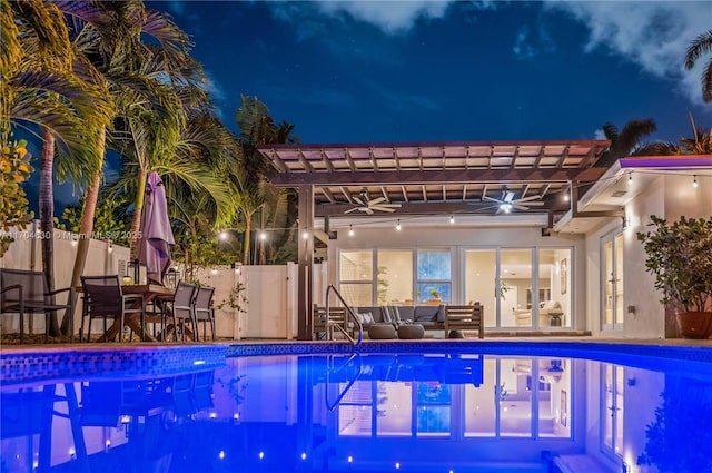 pool at night with outdoor lounge area, a pergola, and a patio