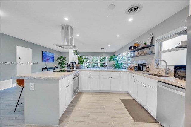 kitchen with kitchen peninsula, appliances with stainless steel finishes, island range hood, and sink