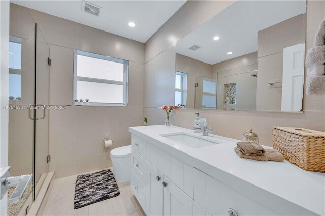 bathroom with tile patterned flooring, vanity, an enclosed shower, and toilet