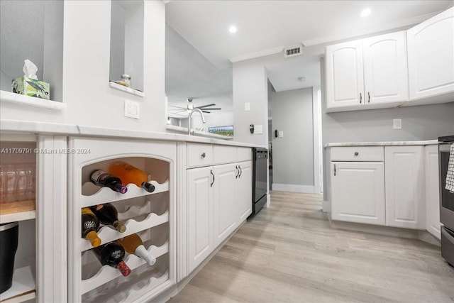 kitchen with white cabinetry, dishwasher, ceiling fan, sink, and light hardwood / wood-style floors