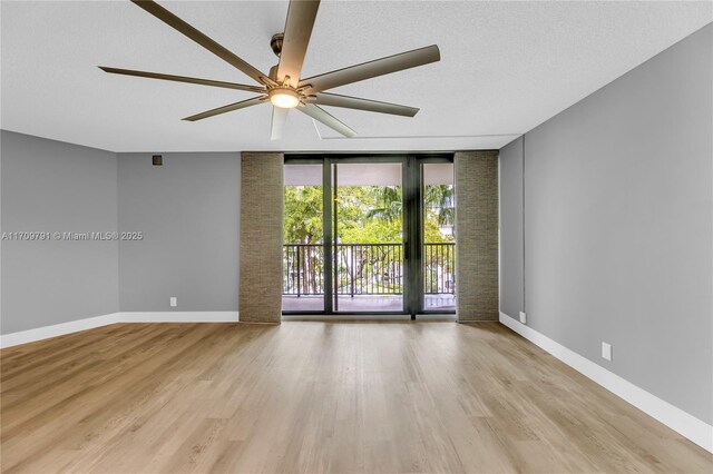 unfurnished room featuring ceiling fan, light wood-type flooring, and a textured ceiling