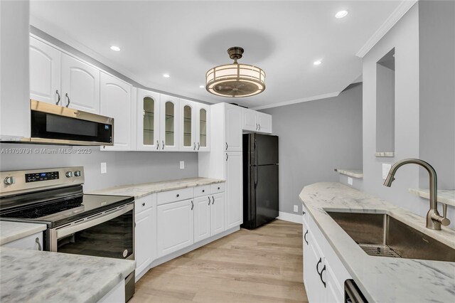 kitchen with appliances with stainless steel finishes, light wood-type flooring, crown molding, sink, and white cabinetry