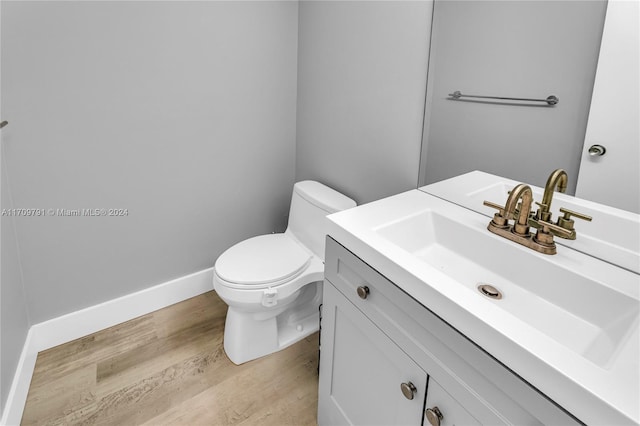 bathroom featuring vanity, wood-type flooring, and toilet