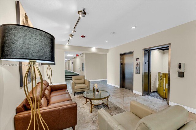 living room with light tile patterned floors, elevator, and track lighting