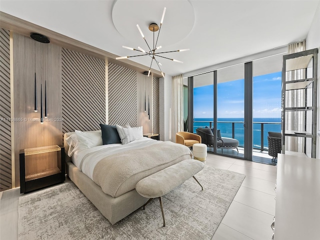 tiled bedroom featuring access to exterior, a chandelier, a water view, and floor to ceiling windows